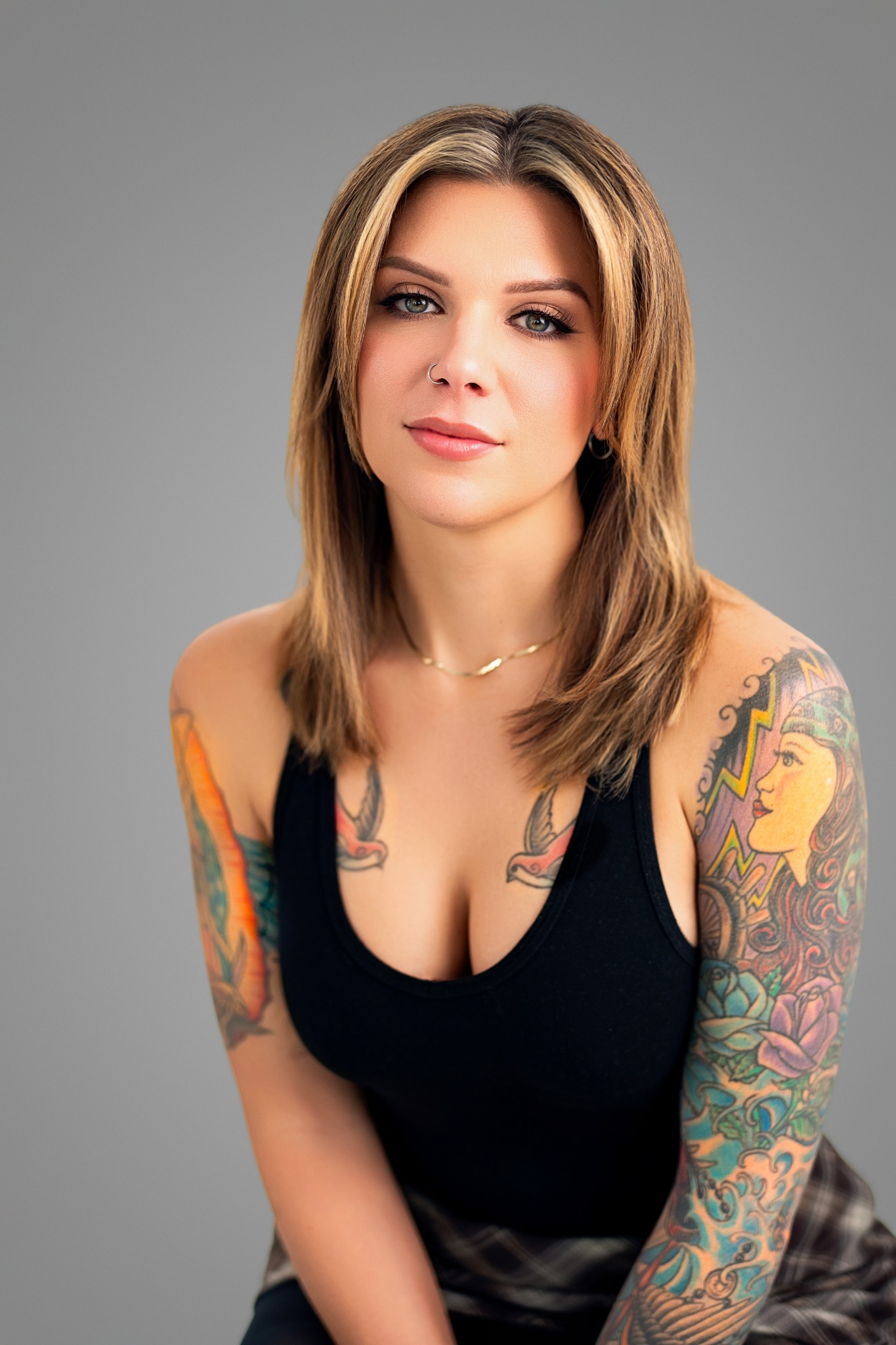 Tattoo artist studio portrait with a grey backdrop